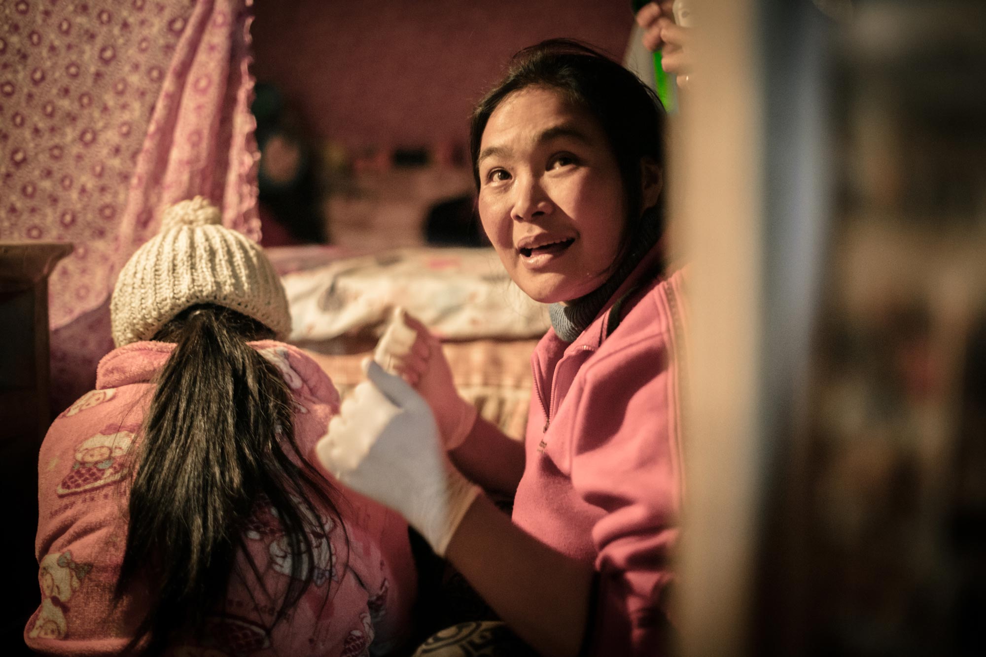 An HPA health worker with rubber gloves on helping another woman